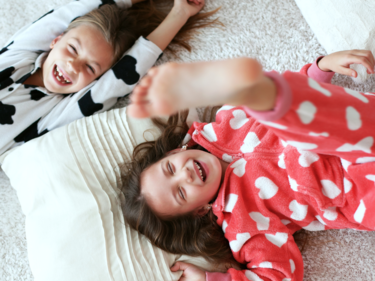 Photo of two children wearing pajamas playing.