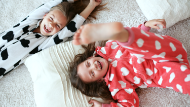 Photo of two children wearing pajamas playing.