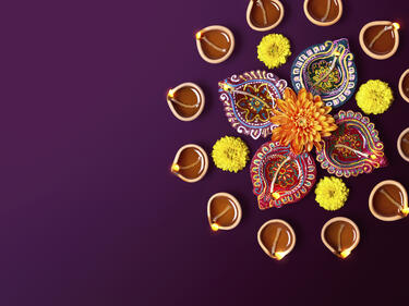 Aerial photo of floral Diwali decorations on a purple background.