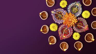 Aerial photo of floral Diwali decorations on a purple background.