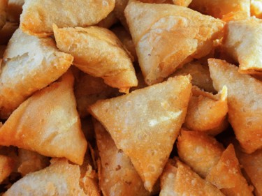 A close up photo of a pile of samosas.