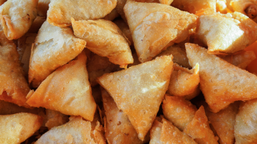 A close up photo of a pile of samosas.