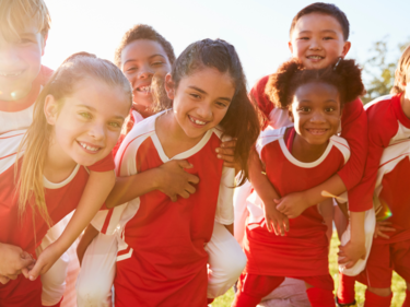 A photo of a group of kids wearing red sports uniforms.