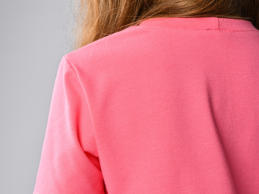 Photo of the back of a student wearing a pink shirt, only the shirt is shown.