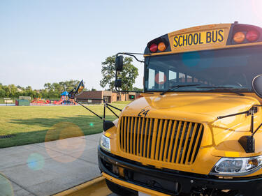 Photo of a school bus in front of a playground/park.