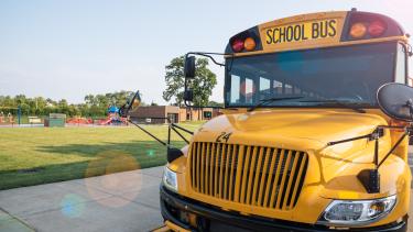Photo of a school bus in front of a playground/park.