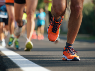 A photo of people running a race, from the knee down.