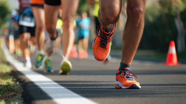 A photo of people running a race, from the knee down.