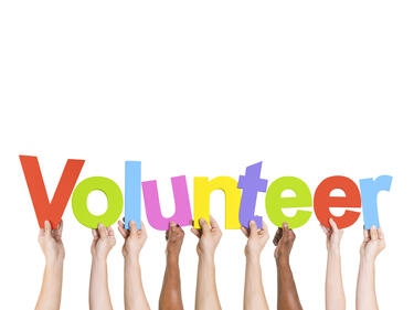 hands raised holding letters of volunteer