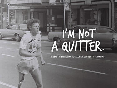 A black and white photo of Terry Fox with a quote reading "I'm not a quitter. Nobody is ever going to call me a quitter - Terry Fox"