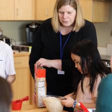 Helping Teacher supporting students with a baking project.