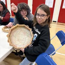 a student poses while working on her drum